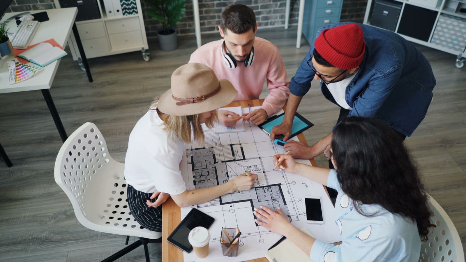 Design team collaborating around architectural plans
